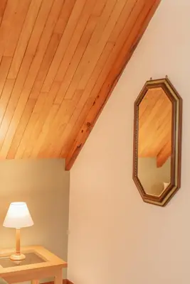 a mirror on a wall next to a table with a lamp at The Attic - Deluxe Leisure Loft in Stellenbosch