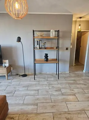 a living room with a tiled floor with a shelf at SS Luxury Apartments Island Club in Cape Town