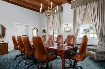 a conference room with a wooden table and leather chairs at Protea Hotel by Marriott Cape Town Mowbray in Cape Town