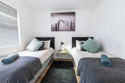 two beds sitting next to each other in a room at Luxury Beachfront Apartment in Blouberg, 304 The Waves in Bloubergstrand