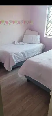 a bedroom with two beds and a window at Self catering three bedroom in Cape Town