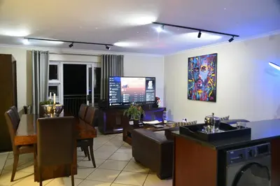 a living room with a kitchen and a dining room at The Perfect Cape Town Retreat in Cape Town