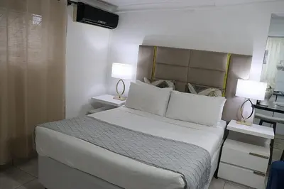 a bedroom with a large white bed with two lamps at Optimum Stay Self Catering Accommodation - Deluxe Room in Cape Town
