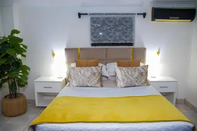 a bedroom with a bed with yellow sheets and pillows at Optimum Stay Self Catering Accommodation - Deluxe Room in Cape Town
