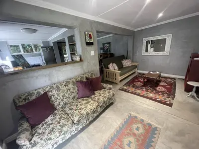 a living room with a couch and a table at Mosselberg Garden Gottage in Hermanus