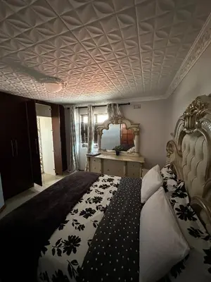 a bedroom with a bed with a black and white comforter at Luxurious 4 bedroom Family Home in Cape Town
