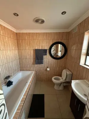a bathroom with a tub and a toilet and a sink at Luxurious 4 bedroom Family Home in Cape Town