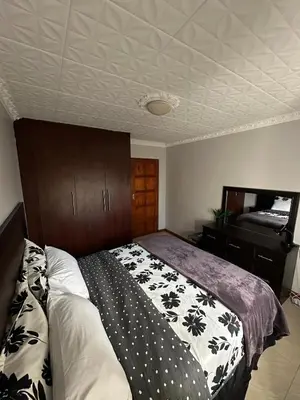 a bedroom with a bed and a television in it at Luxurious 4 bedroom Family Home in Cape Town