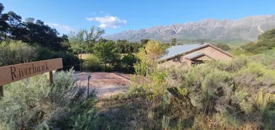 a sign in front of a building with mountains in the background at Riverbank in Tulbagh