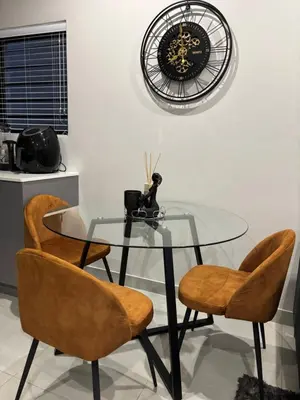 a glass table with two chairs and a clock on the wall at Modern 3 bedroom Urban Getaway in Cape Town