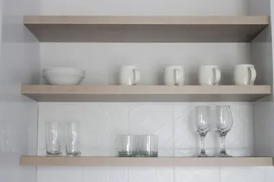 a shelf with wine glasses and bowls on it at Coastal Beach & Mountain Retreat in Cape Town