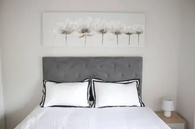 a bedroom with a bed with white flowers on the wall at Coastal Beach & Mountain Retreat in Cape Town