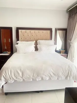 a large white bed with white sheets and pillows at Five bedrooms holiday home in Cape Town