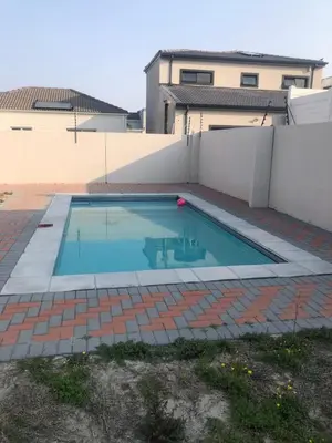 a swimming pool in front of a house at Five bedrooms holiday home in Cape Town