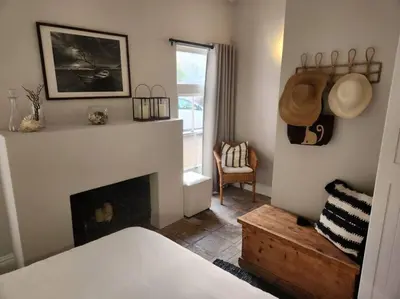 a living room with a fireplace and a chair at No 4 Life at Sea in Strand