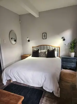 a bedroom with a large white bed with black pillows at No 4 Life at Sea in Strand