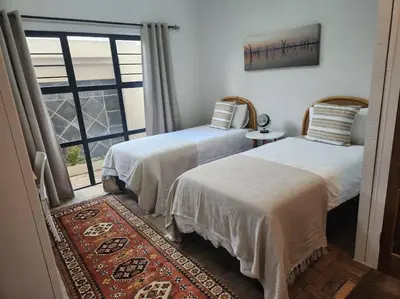 two beds in a room with a window at No 4 Life at Sea in Strand