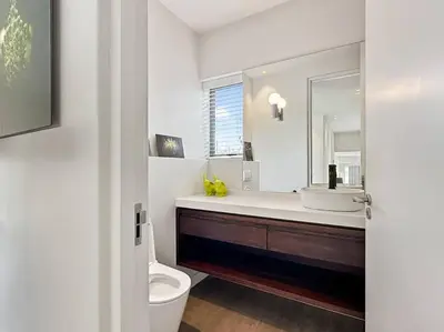 a bathroom with a sink and a toilet and a mirror at Azure Retreat in Hermanus