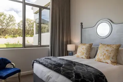 a bedroom with a bed and a large window at Azure Retreat in Hermanus