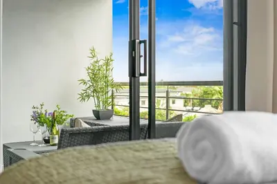 a bedroom with a bed and a balcony with a view at Atlantic Port 10 by Host Agents in Cape Town