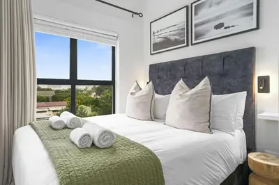 a bedroom with a white bed with towels on it at Atlantic Port 10 by Host Agents in Cape Town