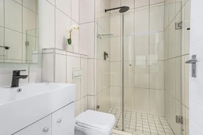 a bathroom with a shower and a toilet and a sink at Atlantic Port 10 by Host Agents in Cape Town