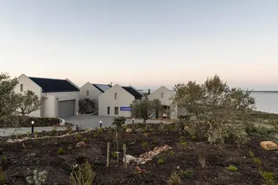 a row of white houses with a garden at Oceanique in Hermanus