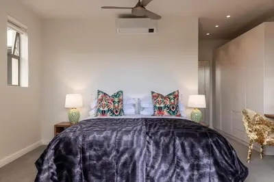 a bedroom with a large bed with colorful pillows at Oceanique in Hermanus