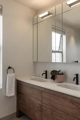 a bathroom with two sinks and a mirror at Oceanique in Hermanus