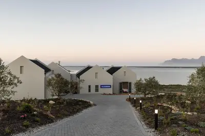 a row of white houses next to the water at Oceanique in Hermanus