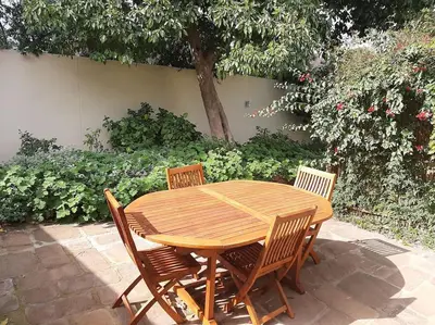 a wooden table with four chairs around it at Klein La Cotte Garden Cottage in Franschhoek