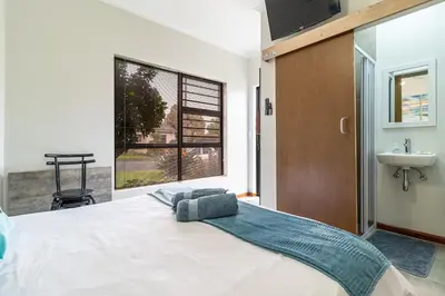 a bedroom with a large white bed and a sink at House of joy in Cape Town