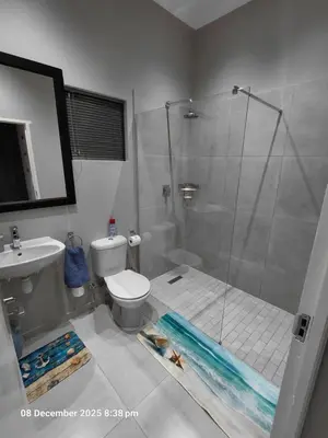 a bathroom with a shower and a toilet and a sink at House of joy in Cape Town