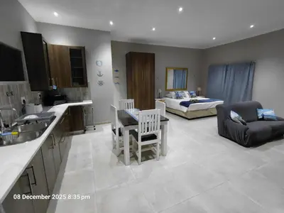 a kitchen and living room with a couch and a bed at House of joy in Cape Town