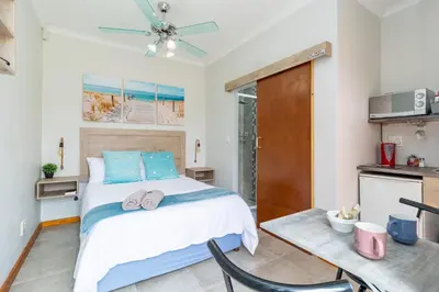 a bedroom with a large bed and a table at House of joy in Cape Town