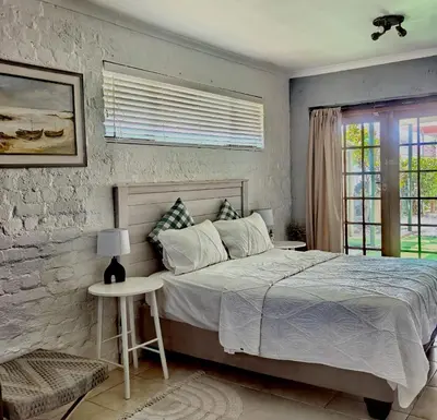 a bedroom with a large bed and a window at Pinelands guesthouse in Cape Town