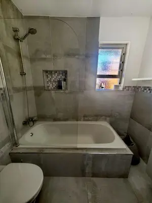 a bathroom with a bath tub and a toilet at Pinelands guesthouse in Cape Town