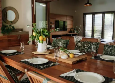 a wooden table with plates and glasses on it at 13 Olives, Entire Grape & Olive Estate, Somerset West by Euphoric Leisure in Sir Lowryʼs Pass