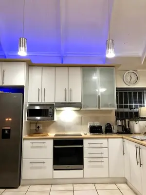 a kitchen with white cabinets and a blue ceiling at #SilverSands Coastal Retreat in Betty's Bay in Bettyʼs Bay