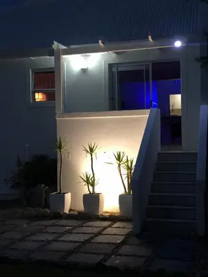 a house with potted plants on the side of it at night at #SilverSands Coastal Retreat in Betty's Bay in Bettyʼs Bay