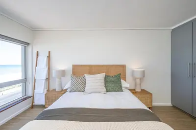 a bedroom with a large bed and a window at 2 Bedroom Apartment - Blouberg Beachfront in Cape Town