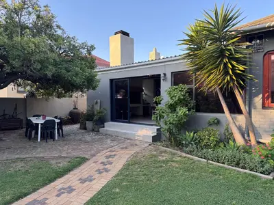 a house with a patio and a table in the yard at Cosy Home with an Ocean Breath! in Cape Town