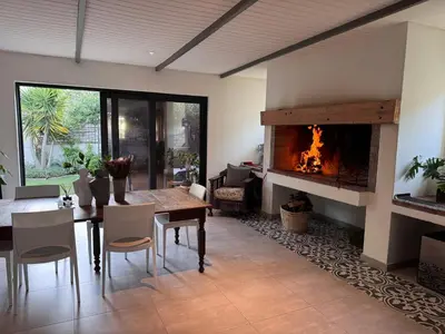 a living room with a table and a fireplace at Cosy Home with an Ocean Breath! in Cape Town