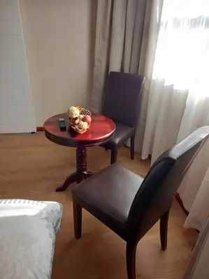 a table and a chair with a bowl on it at Entire Spacious Guest suite in Cape Town in Cape Town