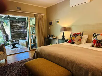 a bedroom with a bed and a sliding glass door at Eight on Tuin in Franschhoek