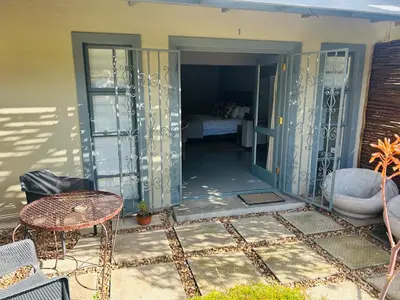 a patio with a table and a bed in a room at Eight on Tuin in Franschhoek
