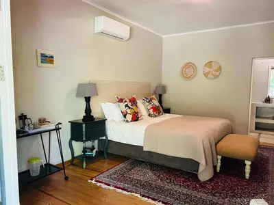 a bedroom with a bed with pillows and a chair at Eight on Tuin in Franschhoek