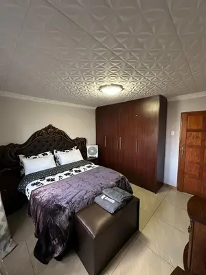 a bedroom with a large bed with a purple comforter at Luxurious 4 bedroom Family Home in Cape Town