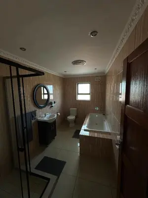a bathroom with a tub and a toilet and a sink at Luxurious 4 bedroom Family Home in Cape Town