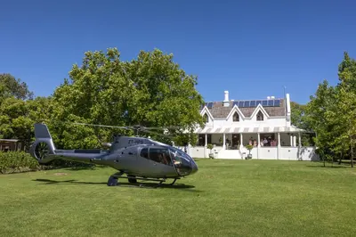 a helicopter parked on the grass in front of a house at The Huts - Glamping at Caledon Grace in Caledon
